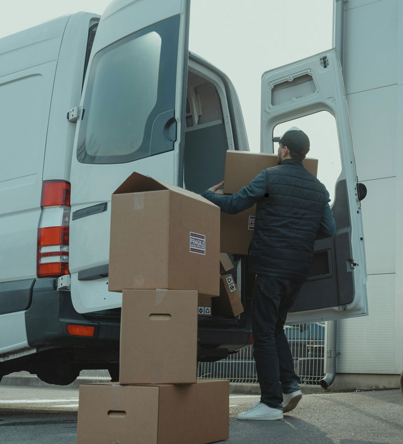 Kuljetustyöntekijä lastaa pakettiautoa